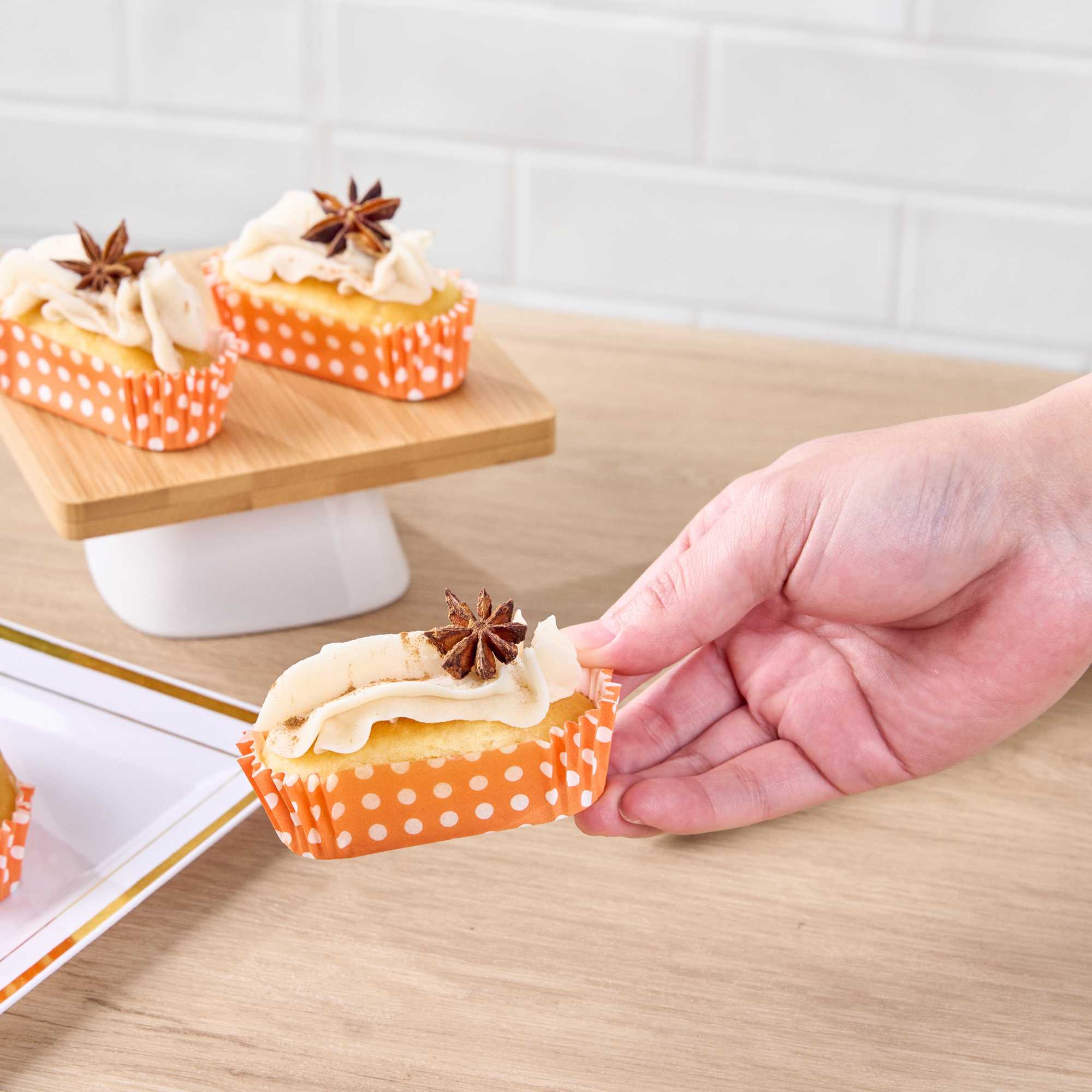 Panificio 1 oz Elliptical Polka-Dotted Hot Orange Paper Regular Baking Cup - Ridged - 3 1/2" x 1 1/2" x 3/4" - 200 count box