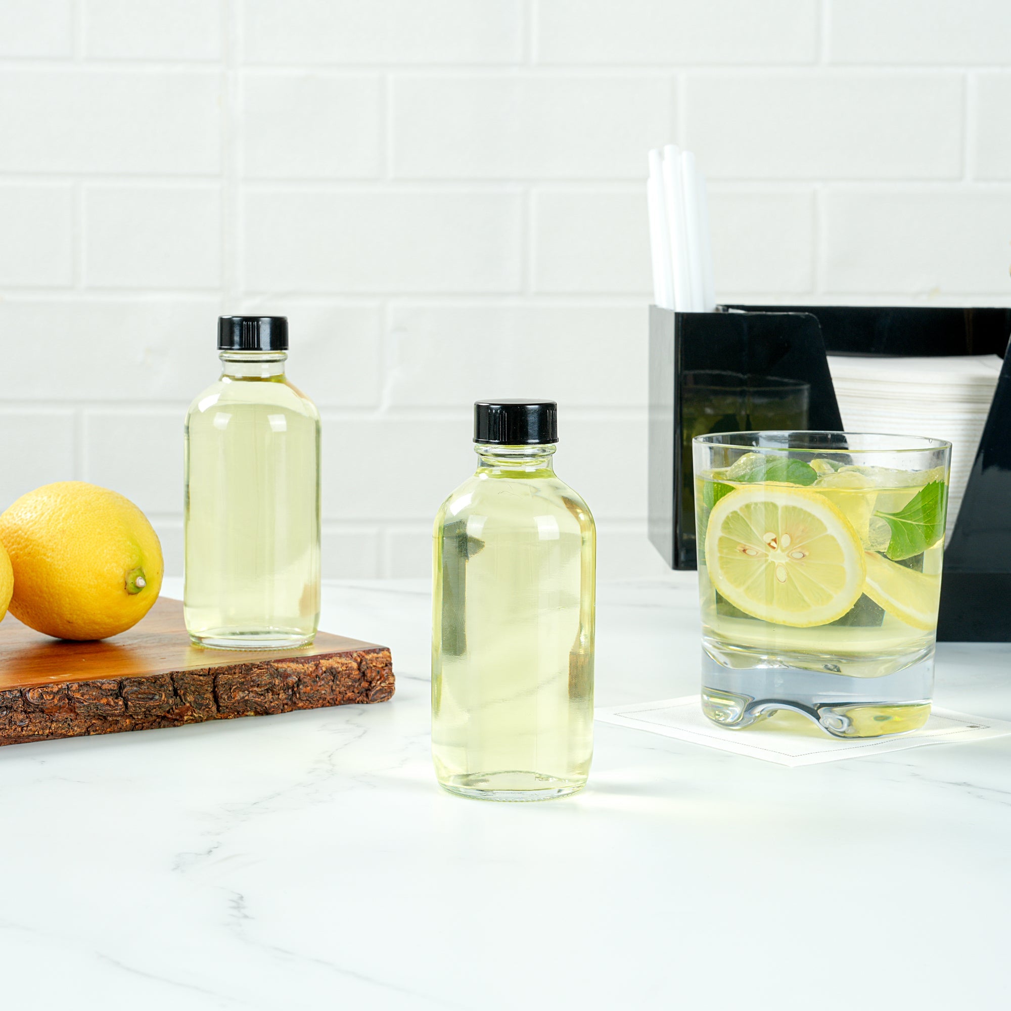 Vetri 4 oz Boston Round Clear Glass Bottle - with Black Phenolic Cap - 2" x 2" x 4 1/2" - 24 count box