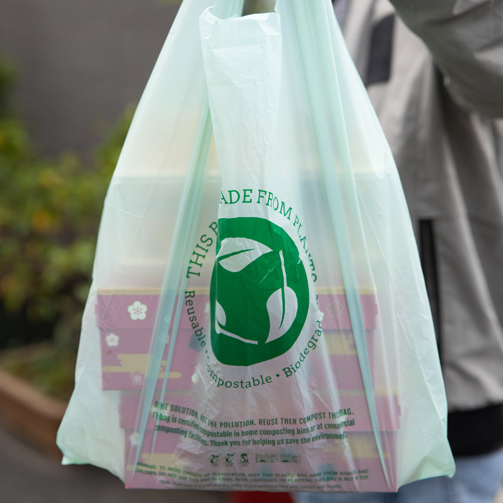 Basic Nature Green Plastic T-Shirt Bag - 1/6 Size, Compostable - 12" x 6 1/2" x 22" - 100 count box