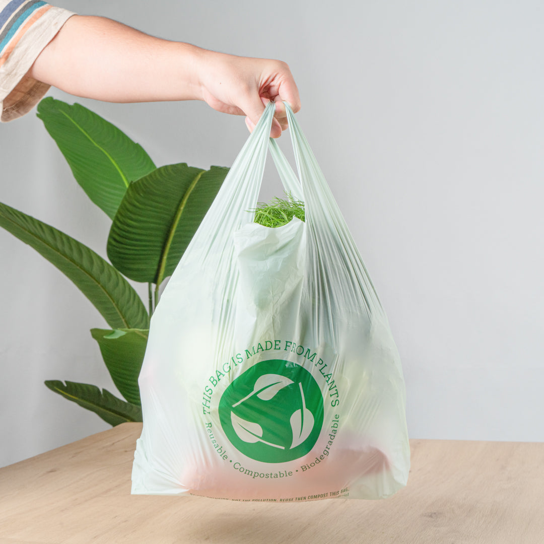 Basic Nature Green Plastic T-Shirt Bag - 1/6 Size, Compostable - 12" x 6 1/2" x 22" - 100 count box